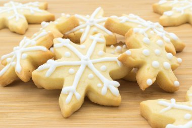 Tahta bir yüzeyde kar tanesi şeklindeki Noel kurabiyeleri..