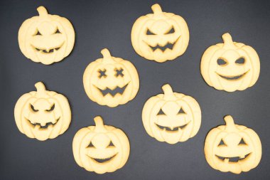 Siyah arka planda Cadılar Bayramı balkabağı şeklinde kurabiyeler.