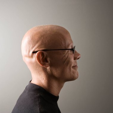 Gri arka planda kel erkek profili 