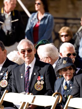 Önde madalyalı gaziler oturuyor. 