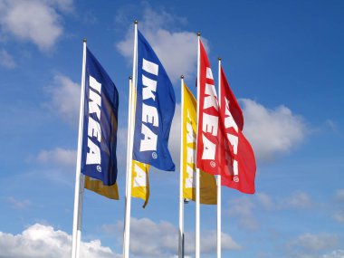 Mavi gökyüzünde bayrakları olan IKEA mağazası