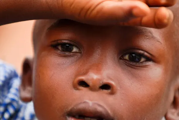 african boy shielding his eyes