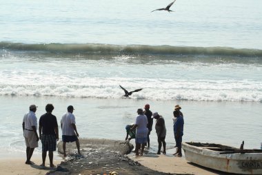 Deniz kıyısında balık tutan insanlar