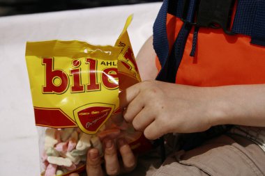 Kid with candy package in hands on boat