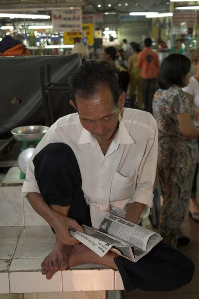 old Asian man Reading the paper