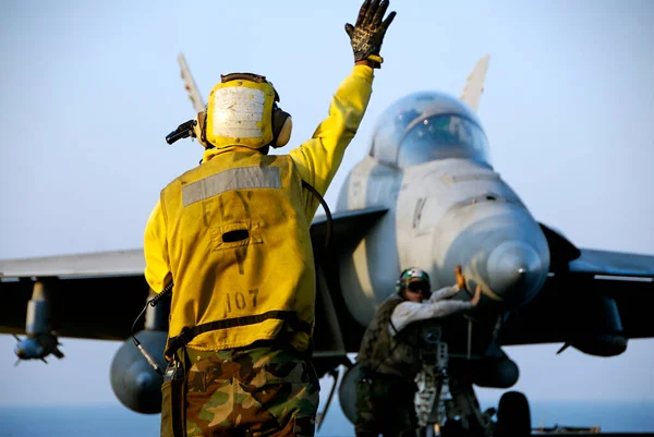 F-18 Hornet and Sailors  with worker and blue sky