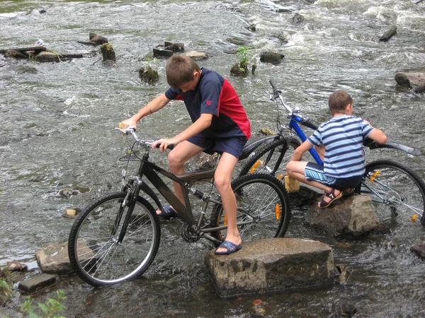 两个骑自行车的男孩在户外 免版税图库照片