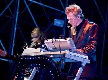 John Taylor sahnede oynuyor.