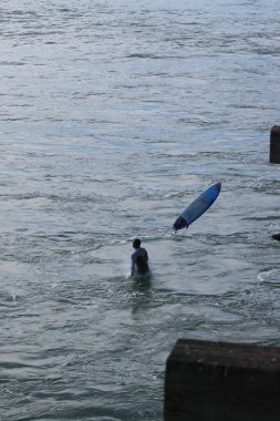 Sörf tahtası olan bir sörfçü. Yaz tatili etkinliği