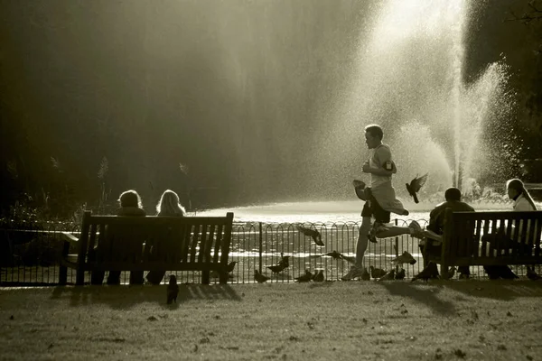 人类沿着喷泉在公园里奔跑 — 图库照片