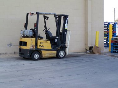 Limandaki depoda sarı bir forklift var.