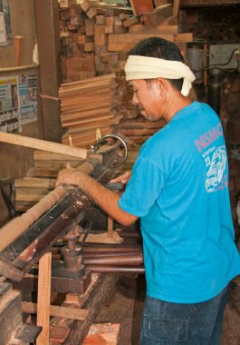 Asyalı erkek marangoz tahtayla çalışıyor.