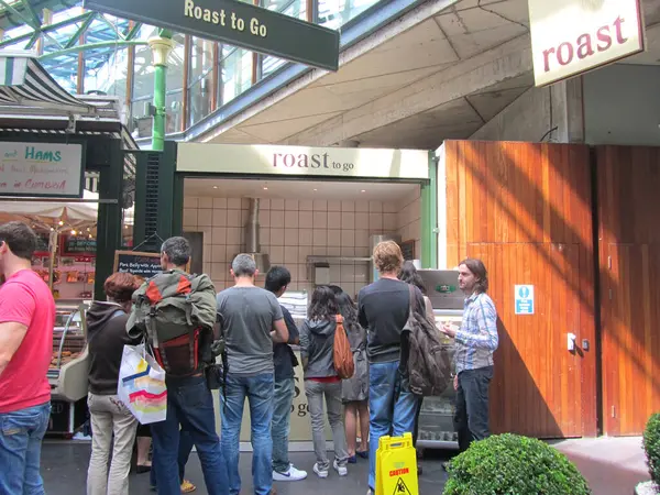 Queue of people at roast meat stall at Borough Market on August