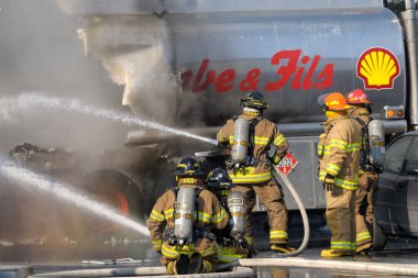 firefighters with a fire and truck on background