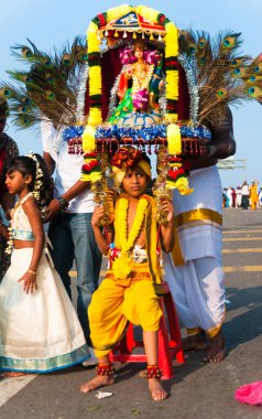 Çocuk mola veriyor. Batu Mağaraları 'ndaki festivalde insanlar