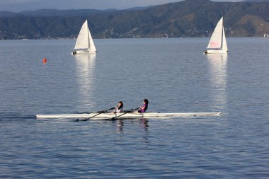 girl kayakers and yachts in water