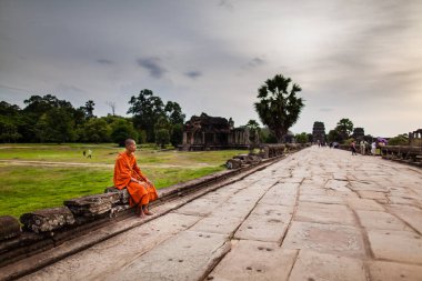 Keşiş Angkor Wat Tapınağının ana geçidinde oturuyor.