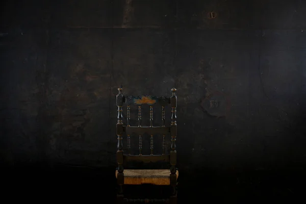 黑色的墙壁背景上的椅子 — 图库照片