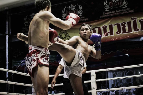 Boks ringinde dövüşen iki üstsüz kaslı adam.