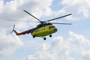 Sarı mi-8 helikopter bulutlar karşı uçar.