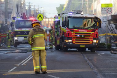 Firefighters and rescue crew attend shop blast clipart