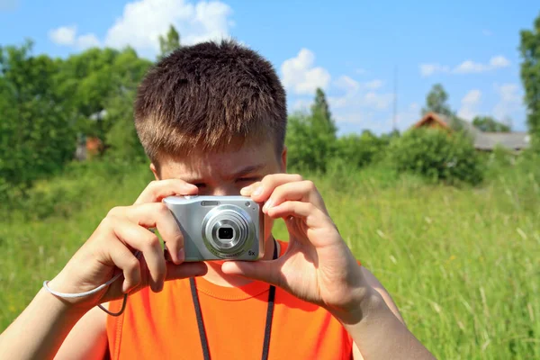 夏の風景を背景にカメラを持った少年 — ストック写真