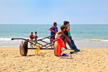 GOA, INDIA - 27 Ocak 2013: Yürürlükteki satış asistanlarının tropikal manzarası 27 Ocak 2013 'te Uttorda Sahili, Goa, Hindistan' da Hint güneşinin altında bir sonraki müşteriyi beklerken karavanda oturdular