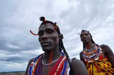 Masai Mara erkekleri geleneksel renkli giysiler içinde Maasai Mara kabilesi köyünde Masai Mara Ulusal Rezervi yakınlarındaki ünlü Safari seyahat merkezinde geleneksel Masai atlayışı dansını gösteriyorlar.