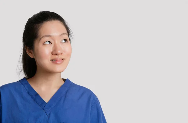 Joven Mujer Asiática Médico Mirando Hacia Arriba Sobre Gris Fondo —  Fotos de Stock