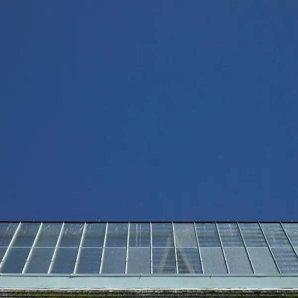 青空の背景にガラス屋根を張った建物 — ストック写真