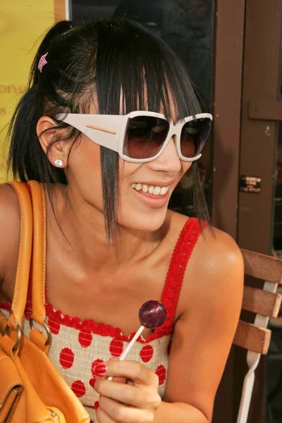 Bai Ling polka elbisesi giyiyor ve kamera önünde lolipop şekeri ile poz veriyor, Hollywood, CA