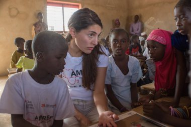 MATAM, SENEGAL - CIRCA NOVEMBER 2013: Actress Caterina Murino greets the children of an elementary school, Caterina Murino is the testimonial of the NGO AMREF, circa November 2013.         