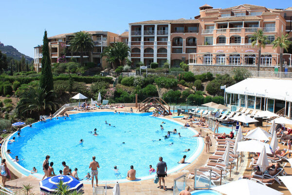 Hotel with people at swimming pool in French Riviera