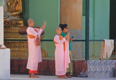 MANDALAY, MYANMAR - 24 Kasım 2015: Budist rahibeler şehirde bir cadde boyunca yürüyorlar 