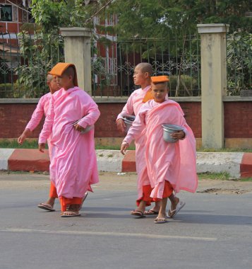 MANDALAY, MYANMAR - 24 Kasım 2015: Budist rahibeler şehirde bir cadde boyunca yürüyorlar 
