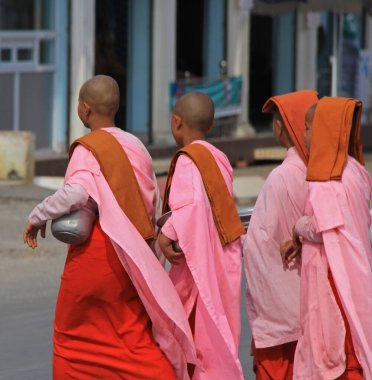 MANDALAY, MYANMAR - 24 Kasım 2015: Budist rahibeler şehirde bir cadde boyunca yürüyorlar 