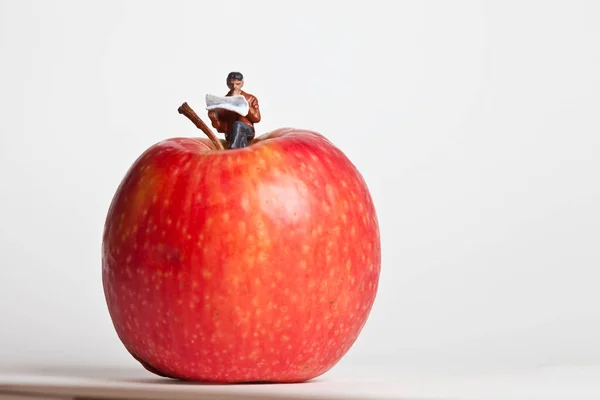 Personas Miniatura Acción Sentadas Sobre Una Manzana —  Fotos de Stock