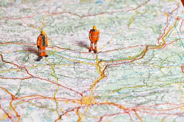 Miniature people in action on a roadmap