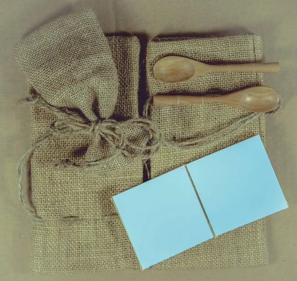 メモ帳と袋表面の背景に木のスプーン — ストック写真
