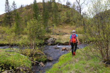 Woman walking near river in mountains
