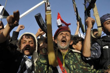 Şii-Houthi destekçileri, 2 Ekim 2015 'te Sanaa' da Suudi liderliğindeki koalisyonun devam eden askeri operasyonlarına karşı düzenlenen gösteride tüfeklerini kaldırdılar..