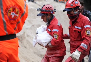 İnsanlar 2 Ekim 2015 'te Guatemala City' nin 15 km doğusundaki Santa Catarina Pinula 'daki El Cambray II köyünde meydana gelen ölümcül çamur kaymasından sonra kurtarabildiklerini kurtarmaya çalışıyorlar.