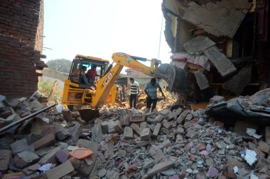 INDIA, Allahabad: İnsanlar, 6 Ekim 2015 'te bir havai fişek fabrikasında meydana gelen patlama sonrasında çöken iki evin enkazının yanında toplanıyorlar. Katılımcımıza göre, havai fişek fabrikası yasa dışı olarak çalışıyordu..