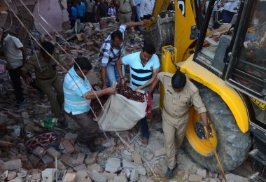 INDIA, Allahabad: İnsanlar, 6 Ekim 2015 'te bir havai fişek fabrikasında meydana gelen patlama sonrasında çöken iki evin enkazının yanında toplanıyorlar. Katılımcımıza göre, havai fişek fabrikası yasa dışı olarak çalışıyordu..
