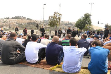 ISRAEL, Kudüs: Güvenlik güçleri, 9 Ekim 2015 'te İsrail' in Eski Kudüs kentinin dışında namaz kılan insanları izliyor.