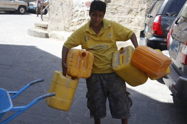 23 Ekim 2015 'te Taiz (Ta' izz), batı Yemen 'deki Nasser okulunda yiyecek ve temiz su dağıtımı sırasında içini su ile doldurmak için bir Yemenli çocuk tarafından taşınır.