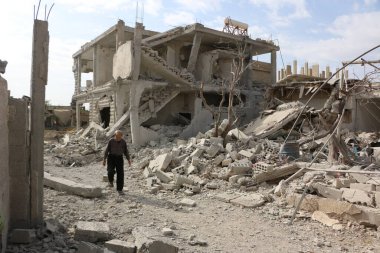 SYRIA, Şam: 24 Ekim 2015 'te Şam' ın doğusundaki Marj al-Sultan Mahallesi 'nde hasarlı binaların arasında Suriyeli bir adam yürüyor.