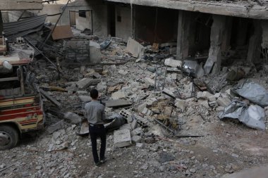 SYRIA, Şam: Suriyeli bir erkek 24 Ekim 2015 tarihinde Şam 'ın doğusundaki Marj al-Sultan mahallesindeki hasarlı binalara bakıyor.