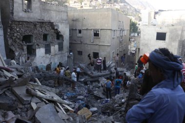 Yemenliler, 1 Kasım 2015 'te Suudi liderliğindeki koalisyonun Taiz, Yemen' deki bir yerleşim bölgesini vurması sonrasında yıkılan binaları teftiş ettiler.