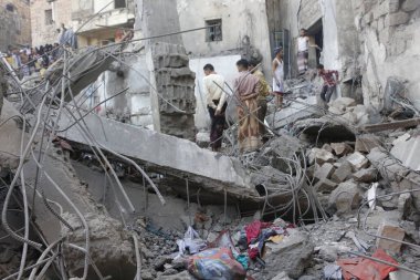 Yemenliler, 1 Kasım 2015 'te Suudi liderliğindeki koalisyonun Taiz, Yemen' deki bir yerleşim bölgesini vurması sonrasında yıkılan binaları teftiş ettiler.
